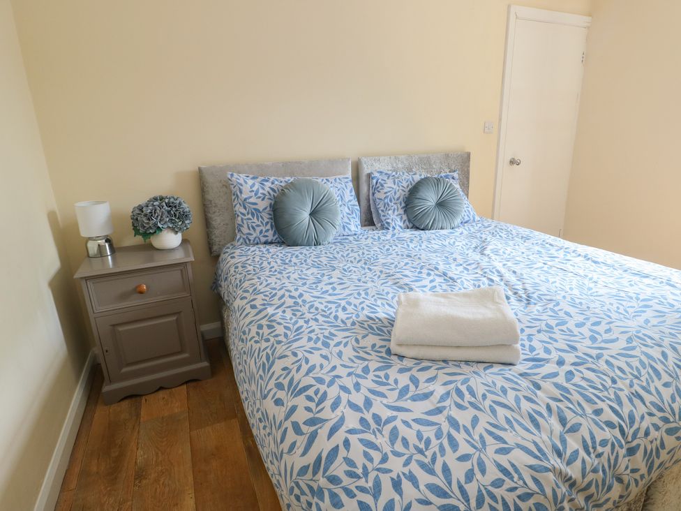 A bedroom with a bed and bedside table at The Bevan in Bontnewydd, Gwynedd