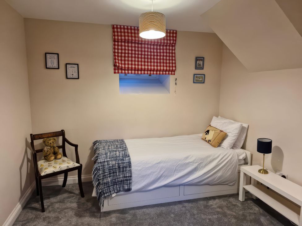 A bedroom with a bed and chair at The Old Nant-y-Fflint Chapel Pentre Halkyn near Holywell