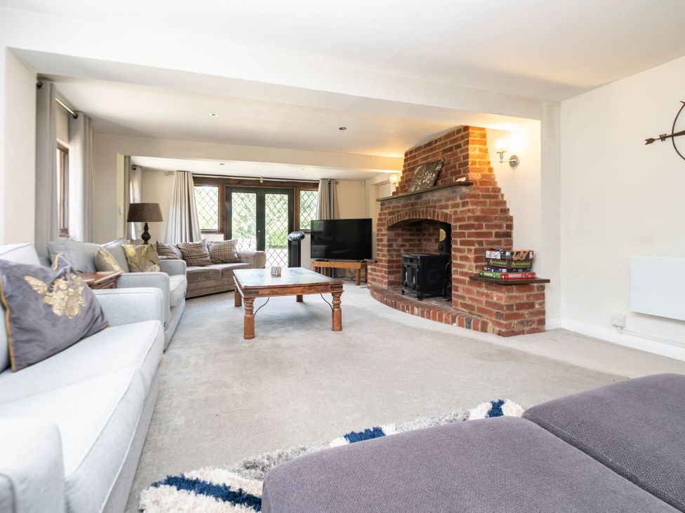 A living room with a fireplace and television at Gildridge Whitesmith near East Hoathly