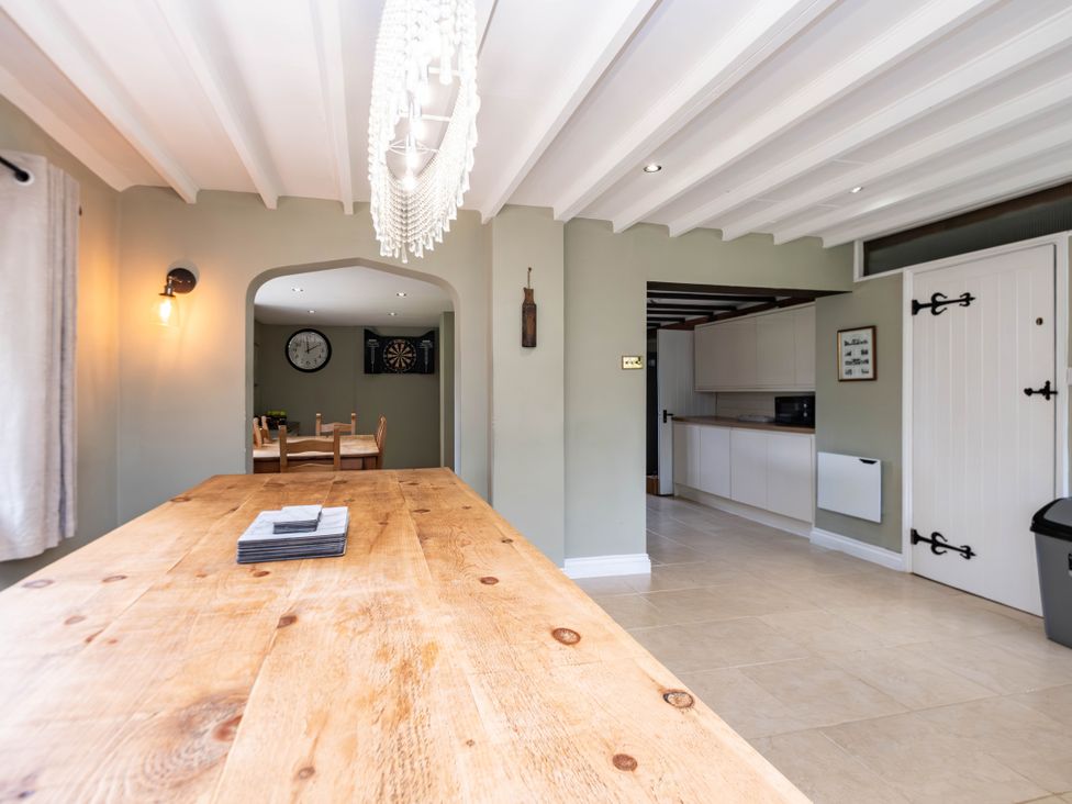 A dining room with a wooden table and chairs at Gildridge Whitesmith near East Hoathly