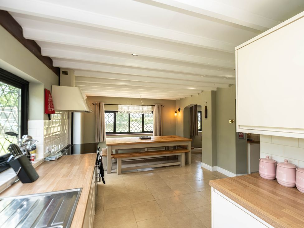 A kitchen with a dining table and cabinets at Gildridge Whitesmith near East Hoathly