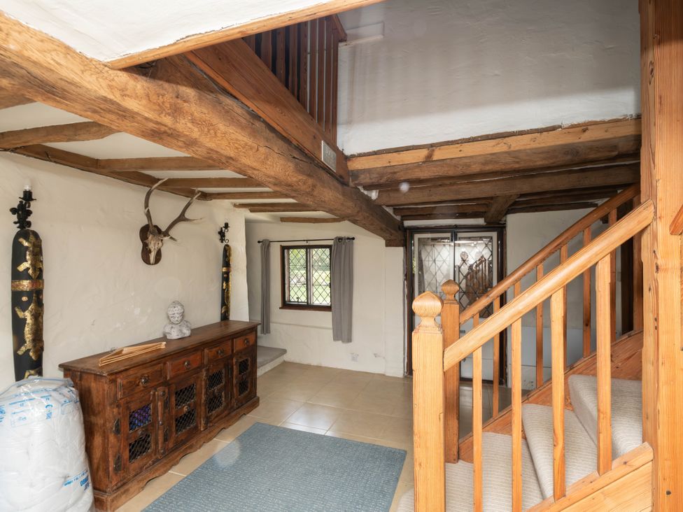 An entrance hall with a staircase and console table at Gildridge Whitesmith near East Hoathly