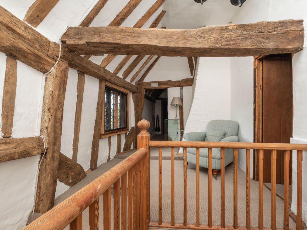 A hallway with wooden beams and a chair at Gildridge in Whitesmith near East Hoathly