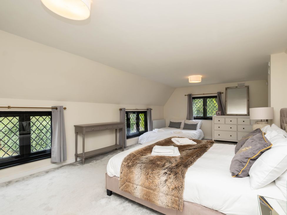 A bedroom with two beds and windows at Gildridge in Whitesmith near East Hoathly