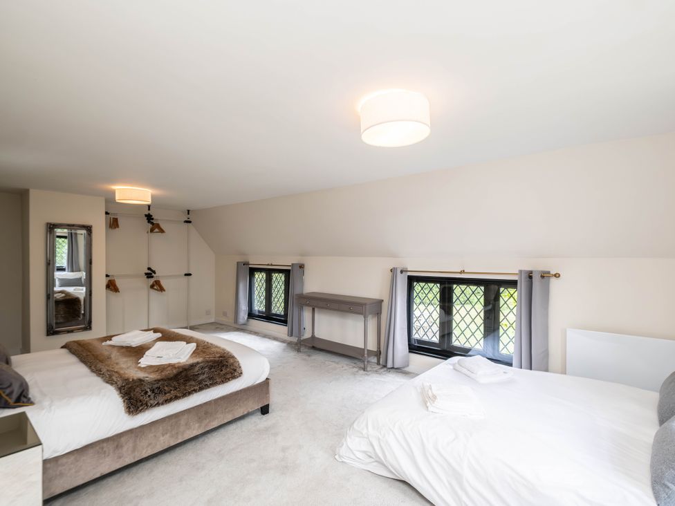 A bedroom with two beds and a table at Gildridge in Whitesmith near East Hoathly