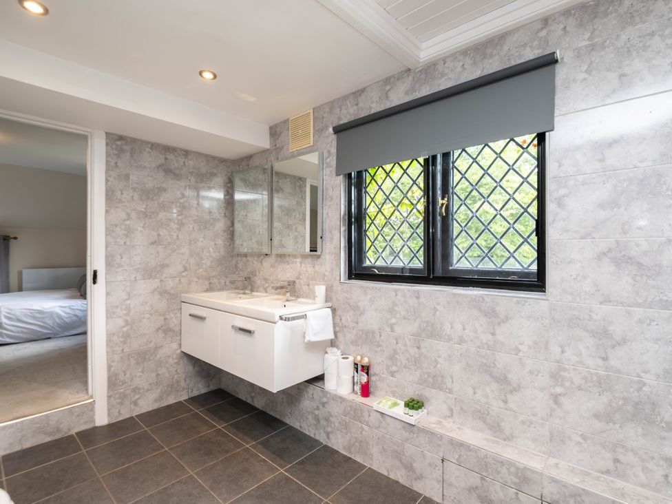 A bathroom with a sink and mirrors at Gildridge in Whitesmith near East Hoathly