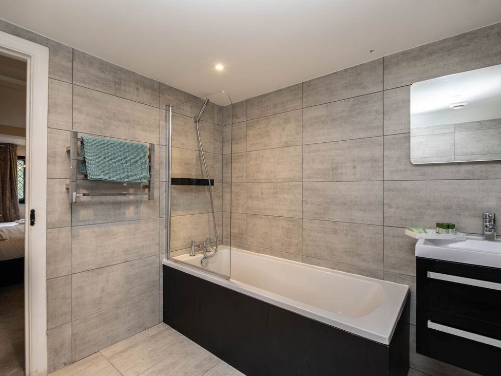 A bathroom with a bathtub and sink at Gildridge near East Hoathly