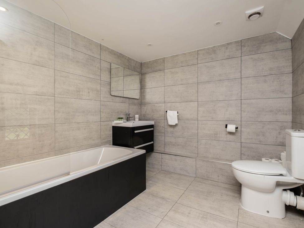 A bathroom with a bathtub, toilet, and sink at Gildridge in Whitesmith near East Hoathly