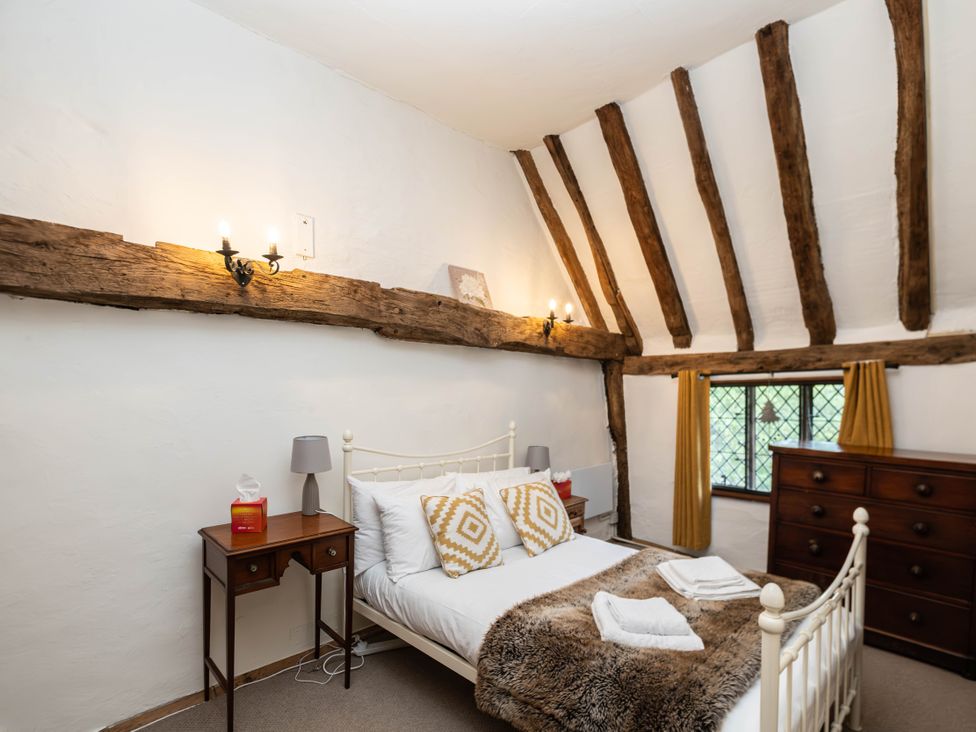 A bedroom with a bed and table at Gildridge in Whitesmith near East Hoathly