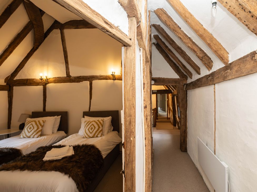 A bedroom with twin beds and wooden beams at Gildridge in Whitesmith near East Hoathly