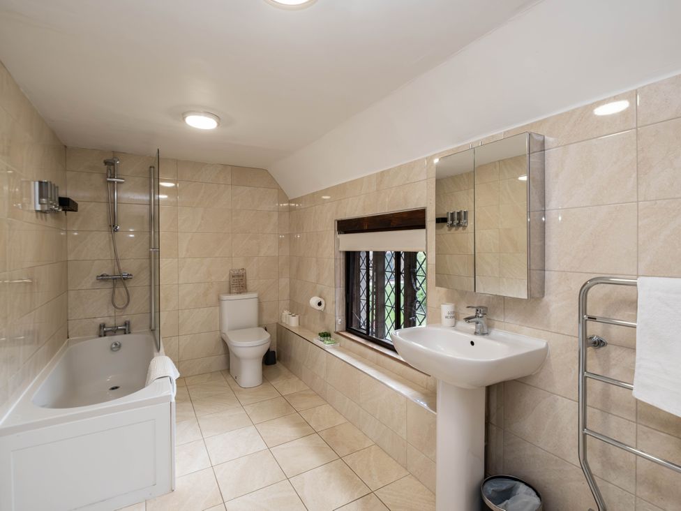 A bathroom with a bathtub, toilet, sink, and shower at Gildridge in Whitesmith near East Hoathly