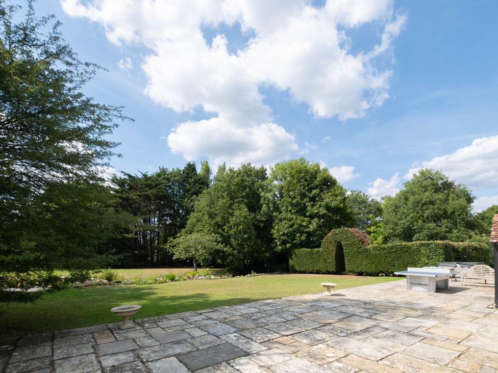 A garden with a patio and trees at Gildridge in Whitesmith near East Hoathly
