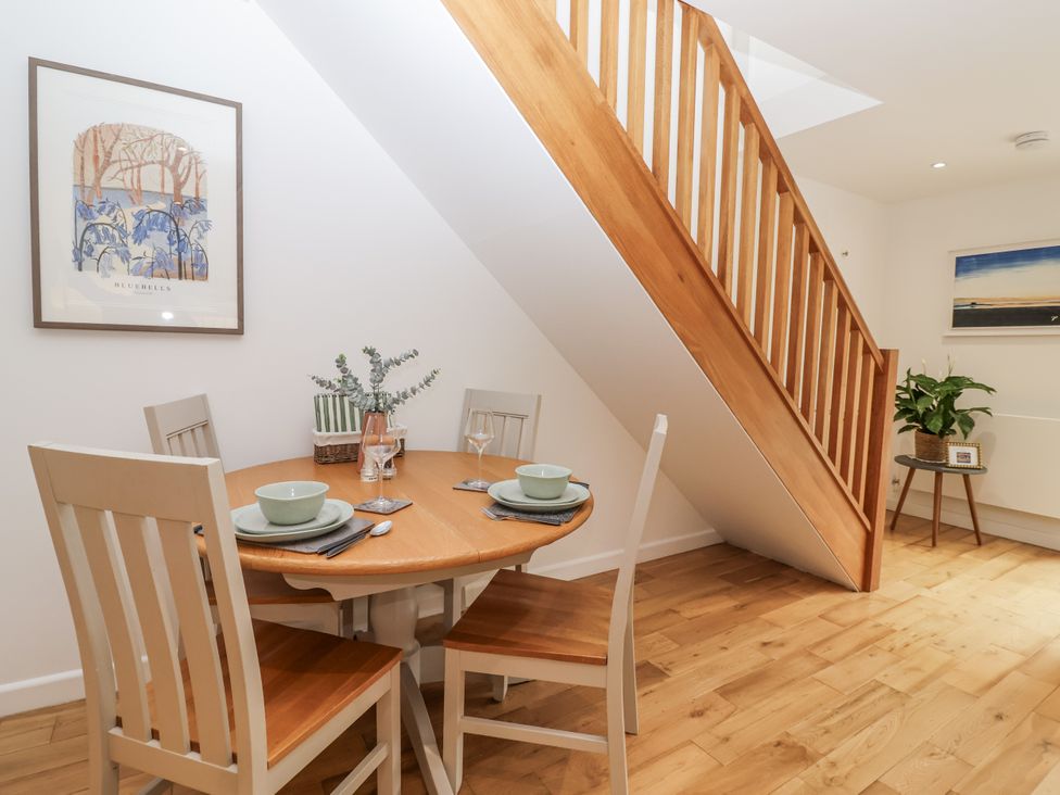 A dining area with a round table and chairs at Mariners Rest in Gorran Haven