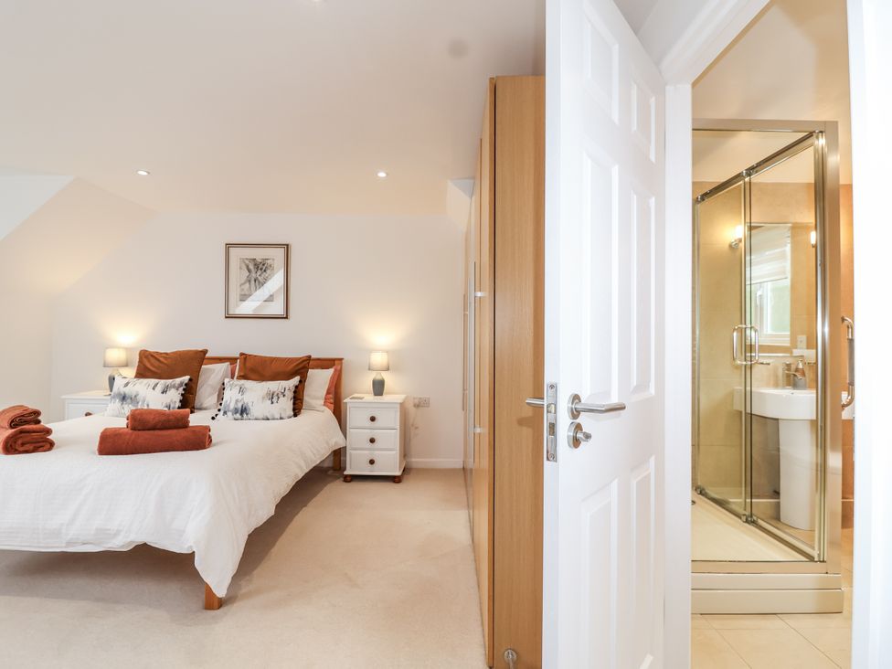 A bedroom with a bed and attached shower at Mariners Rest in Gorran Haven