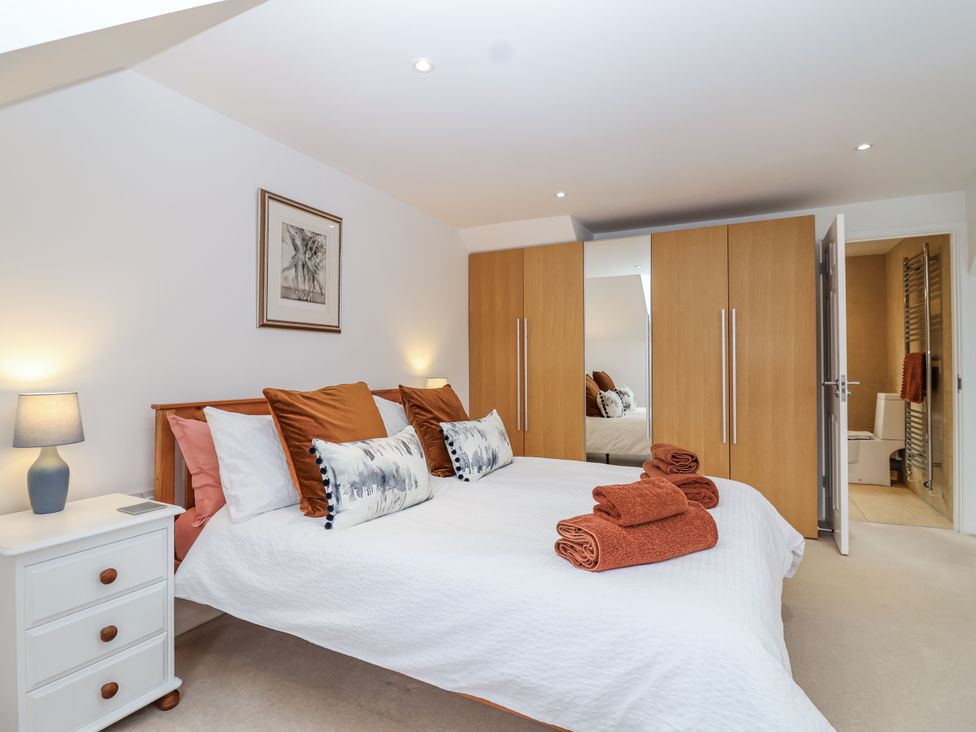 A bedroom with a bed and wardrobe at Mariners Rest in Gorran Haven