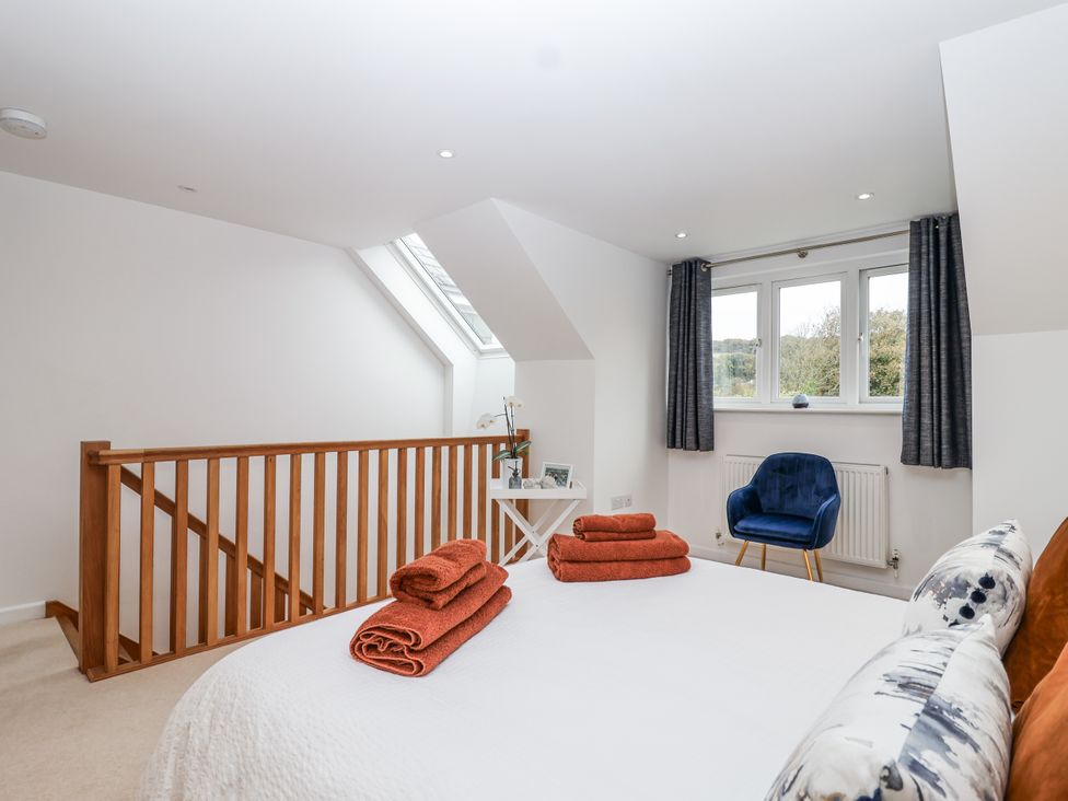 A bedroom with a bed and towels on display at Mariners Rest in Gorran Haven