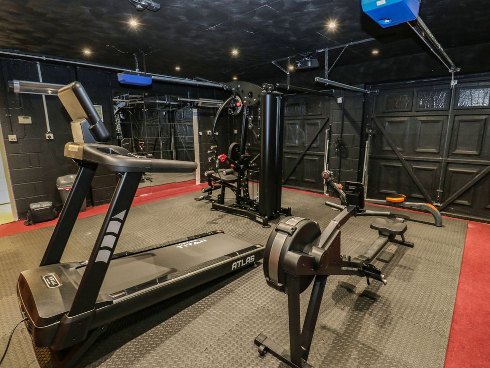 A gym with exercise equipment including a treadmill and weight machine at Akila, Grasscroft near Greenfield
