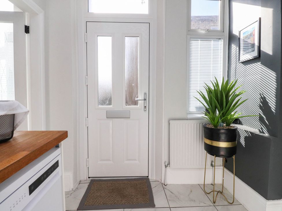 A hallway with a door and a plant at 4 Green Street Keighley