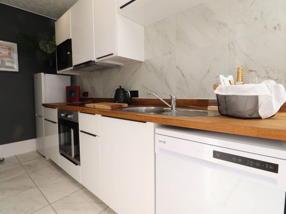 A kitchen with a sink, oven, and refrigerator at 4 Green Street in Keighley