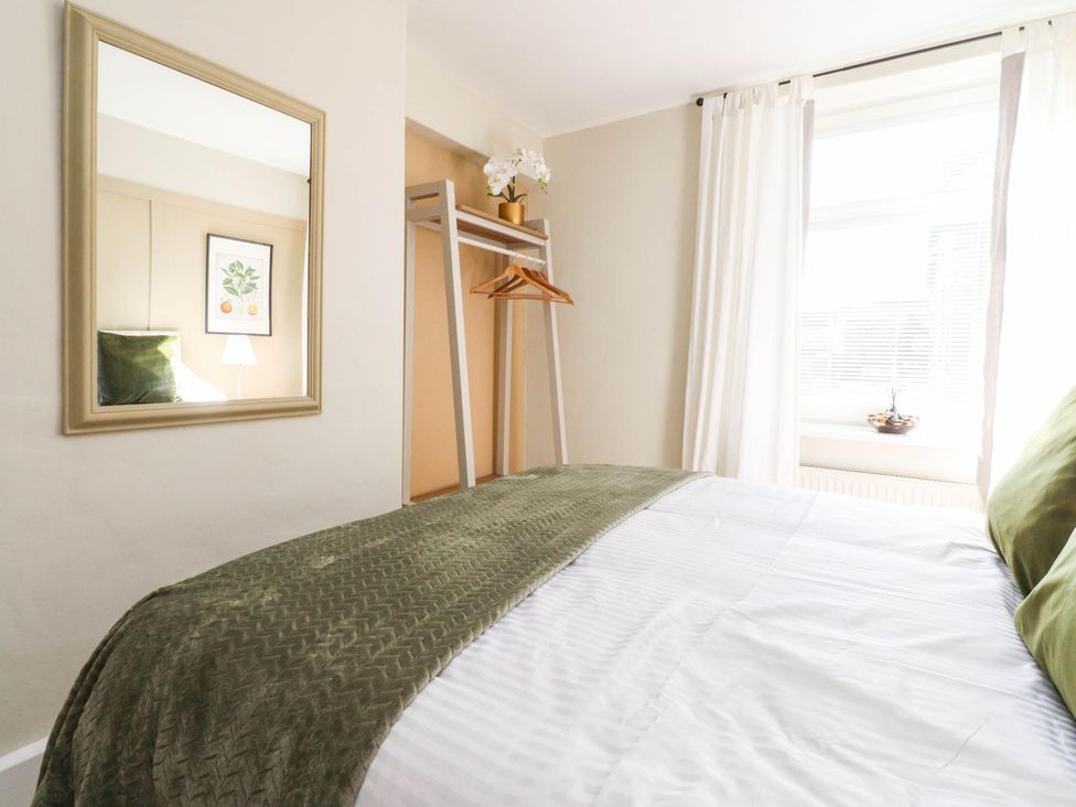 A bedroom with a bed and a mirror at 4 Green Street in Keighley