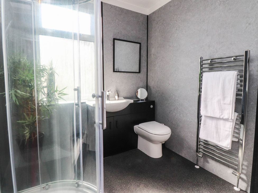 A bathroom with a shower, sink, and toilet at 4 Green Street Keighley
