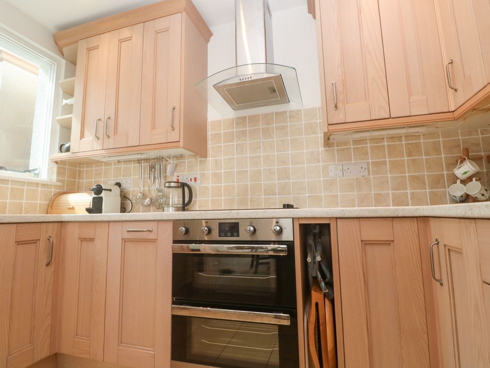 A kitchen with cabinets, oven, counter, and utensils at Flat 2, Moonrakers in St. Ives