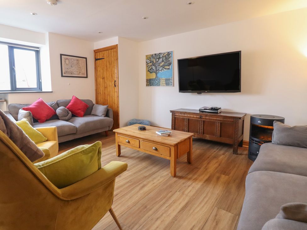 A living room with a coffee table and television at The Granary in Welshpool