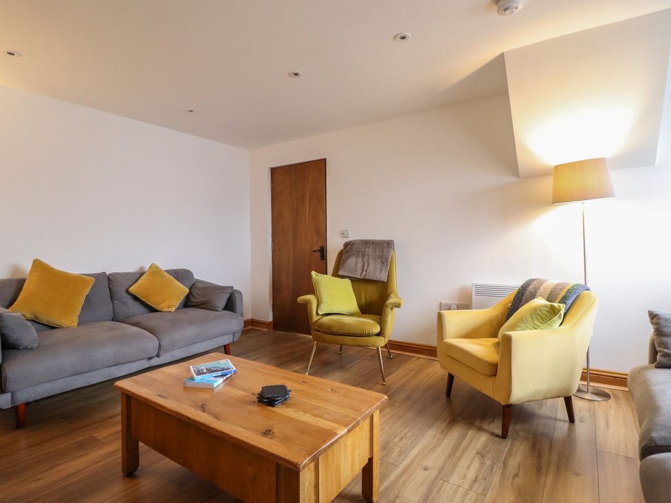 A living room with a sofa and armchair at The Granary in Welshpool