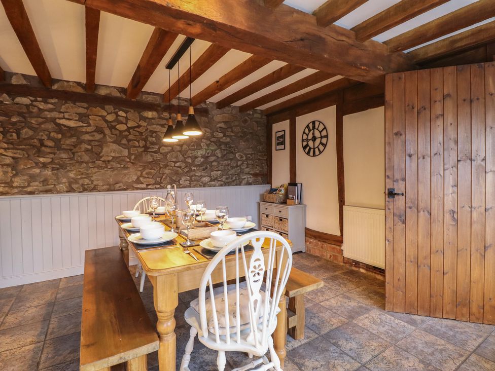 A dining room with a wooden table and chairs at The Granary in Welshpool
