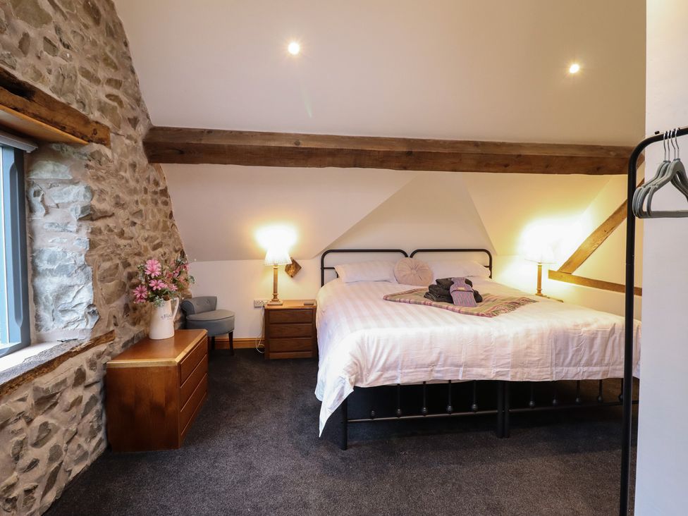 A bedroom with a bed and nightstand at The Granary in Welshpool