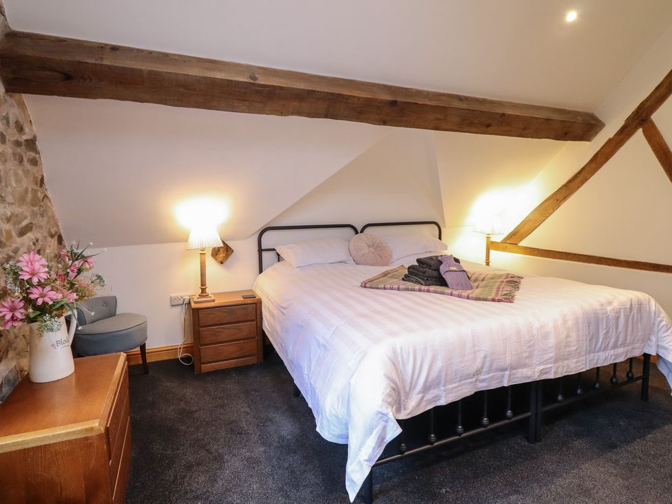 A bedroom with a bed and side table at The Granary in Welshpool