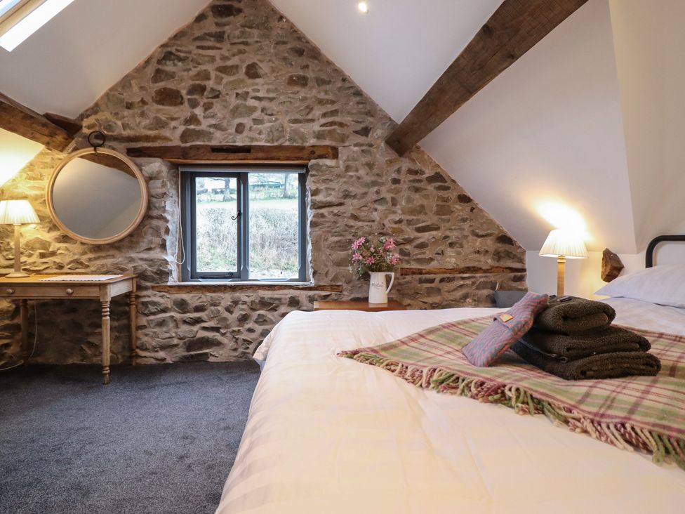 A bedroom with a bed and a table at The Granary in Welshpool