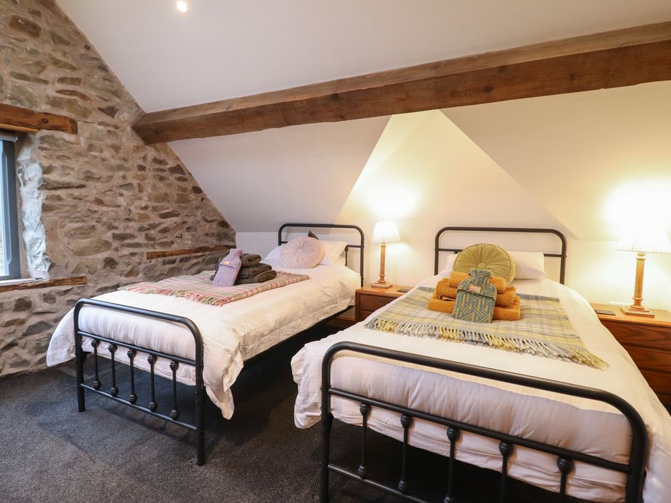 A bedroom with two beds and wooden beams at The Granary in Welshpool