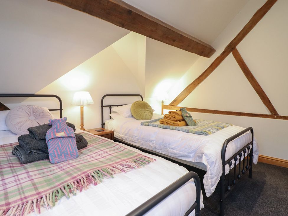 A bedroom with two beds and a lamp at The Granary in Welshpool