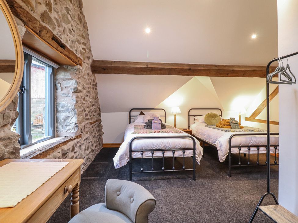 A bedroom with two beds and a window at The Granary in Welshpool