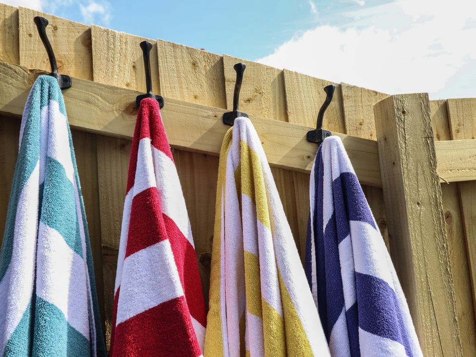 Towels hanging on hooks on a wooden fence at The Granary in Llangyniew near Llanfair Caereinion