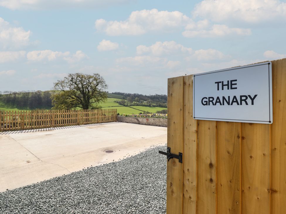An outdoor area with a gravel path and a sign at The Granary in Llangyniew near Llanfair Caereinion