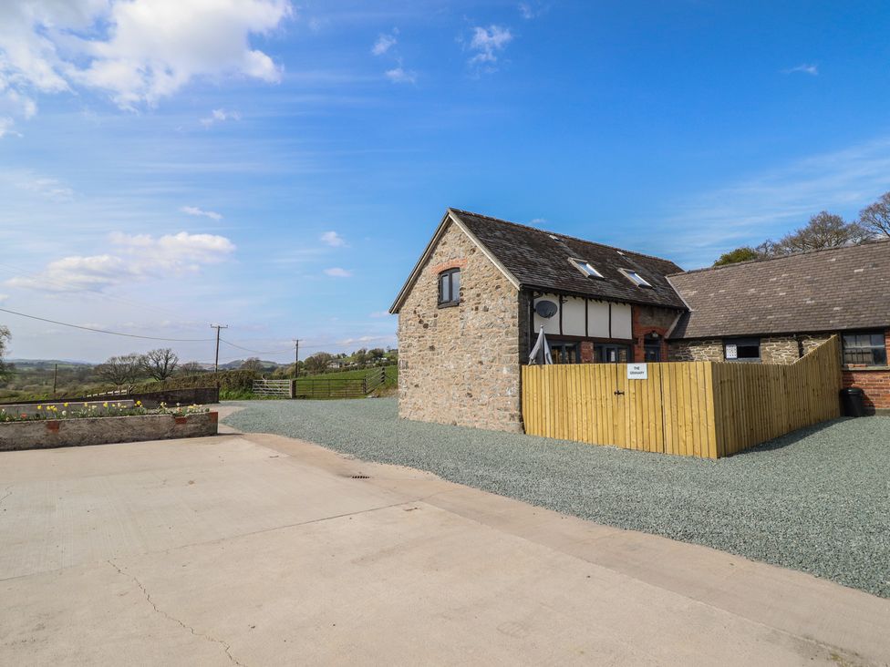 An outdoor area with a gravel surface and a building at The Granary in Llangyniew near Llanfair Caereinion