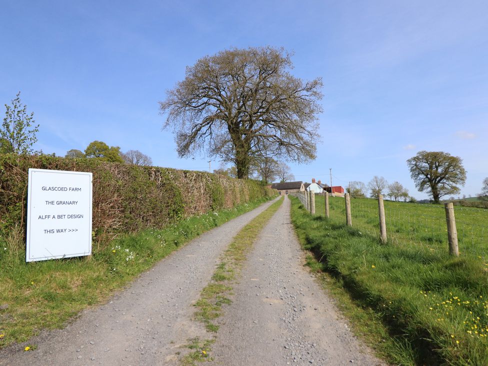 A road leading to Glascoed Farm with a sign at The Granary in Llangyniew near Llanfair Caereinion