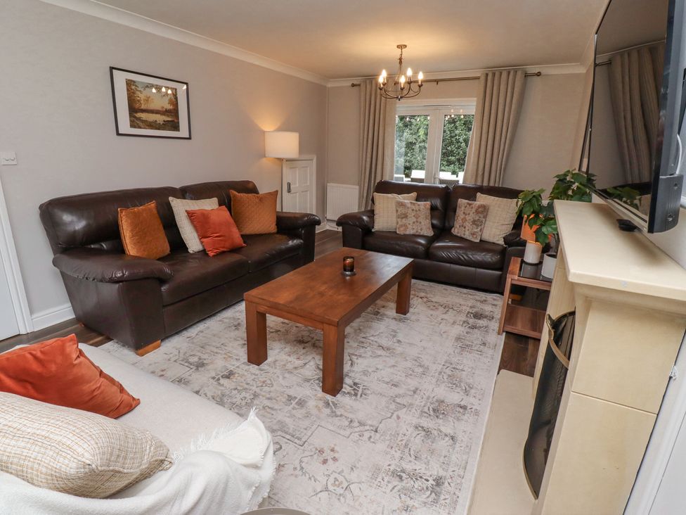 A living room with two brown leather sofas a beige sofa and a wooden coffee table at Sparrow House in Alnwick