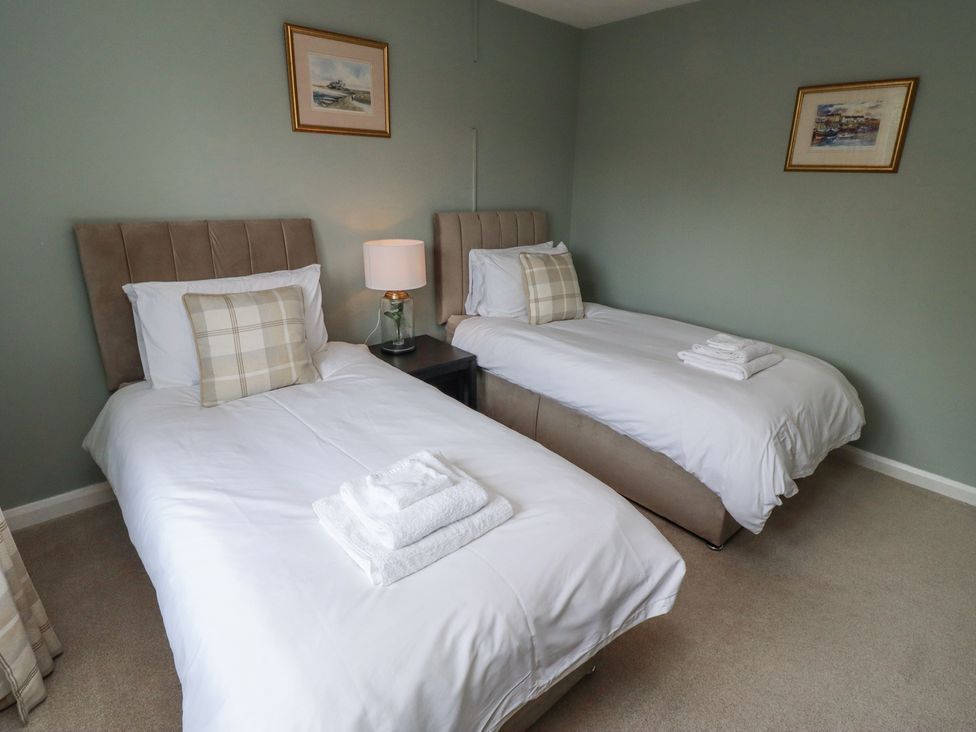 A bedroom with two single beds with white bedding and folded towels on top at Sparrow House in Alnwick