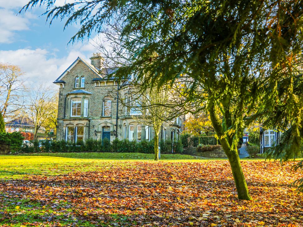 A building with grass and trees in front at Castleton Suite in Buxton