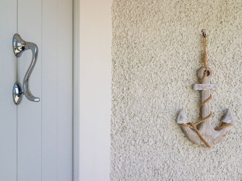 A door handle and a decorative anchor on a wall at Hafod Y Bryn Harlech