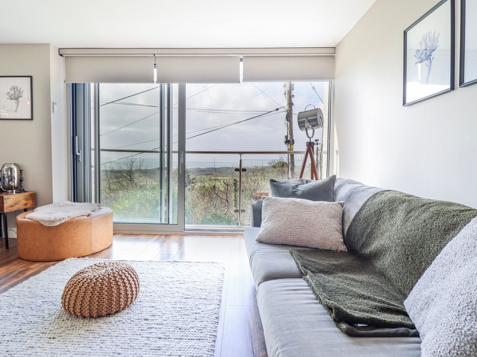 A living room with a sofa and large windows at Hafod Y Bryn in Harlech