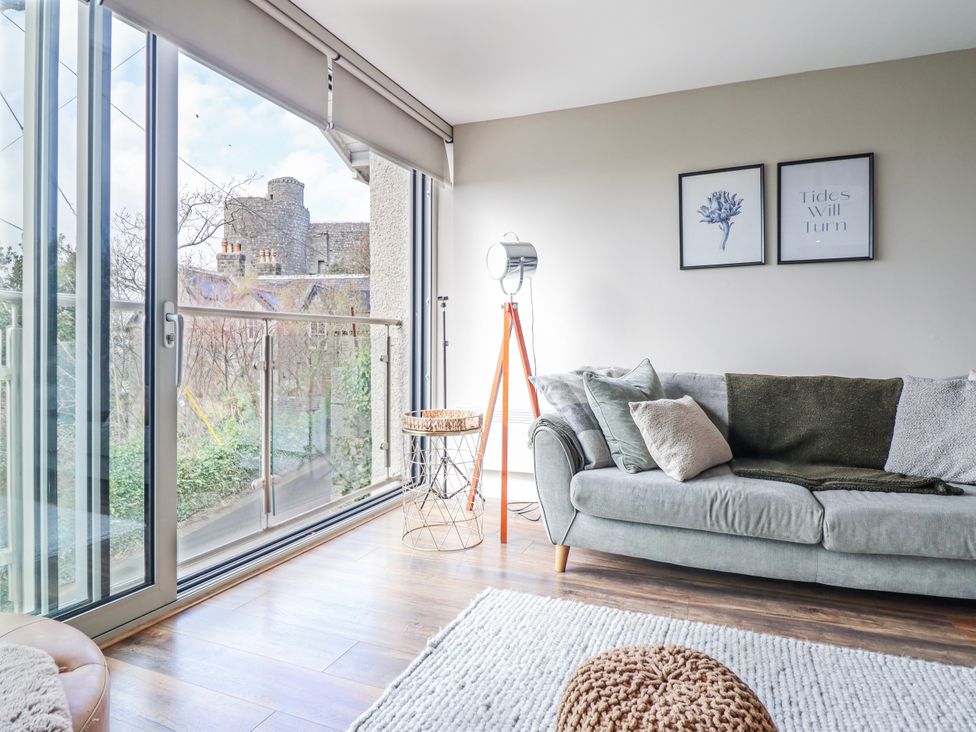 A living room with a sofa and floor lamp at Hafod Y Bryn Harlech