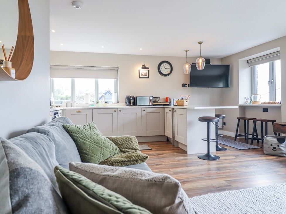 A kitchen with stools and appliances at Hafod Y Bryn Harlech