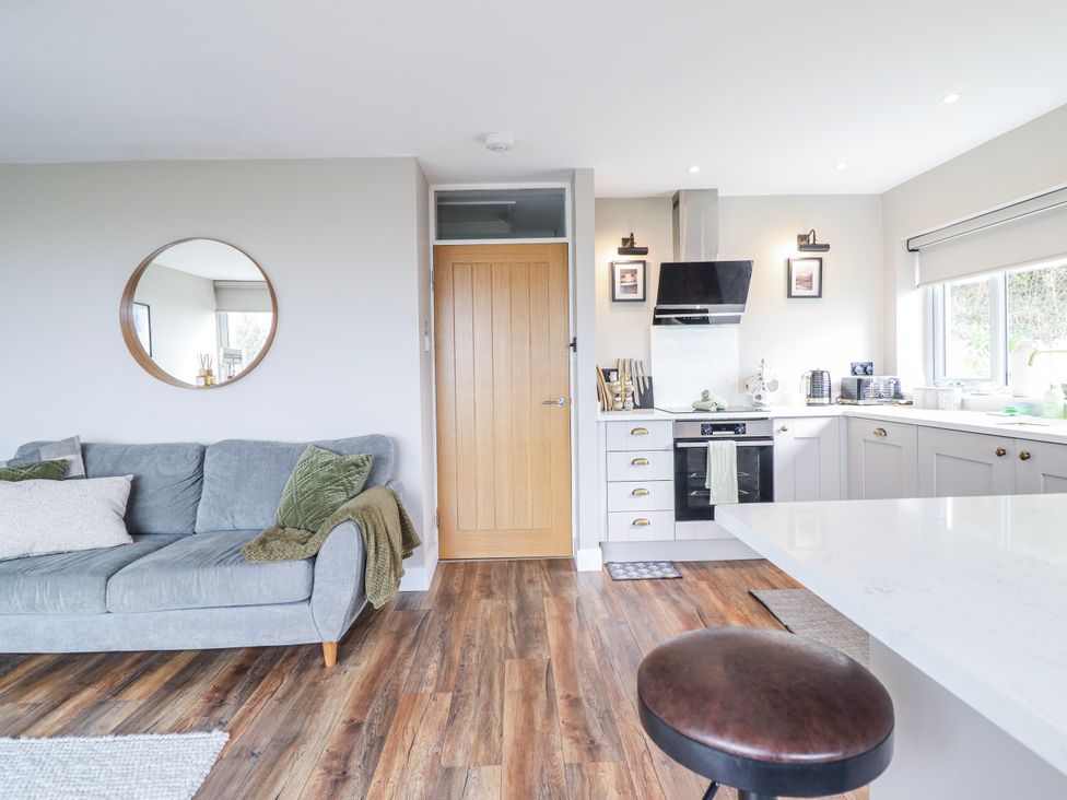 A kitchen with a sofa and door at Hafod Y Bryn in Harlech