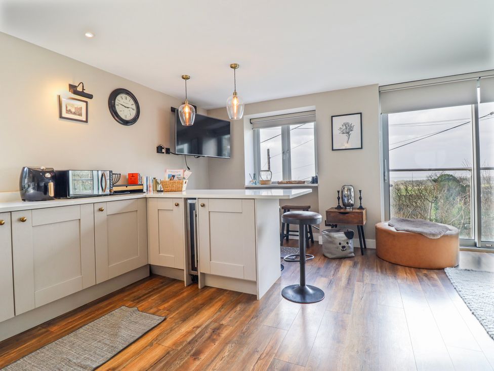 A kitchen with appliances and seating at Hafod Y Bryn Harlech