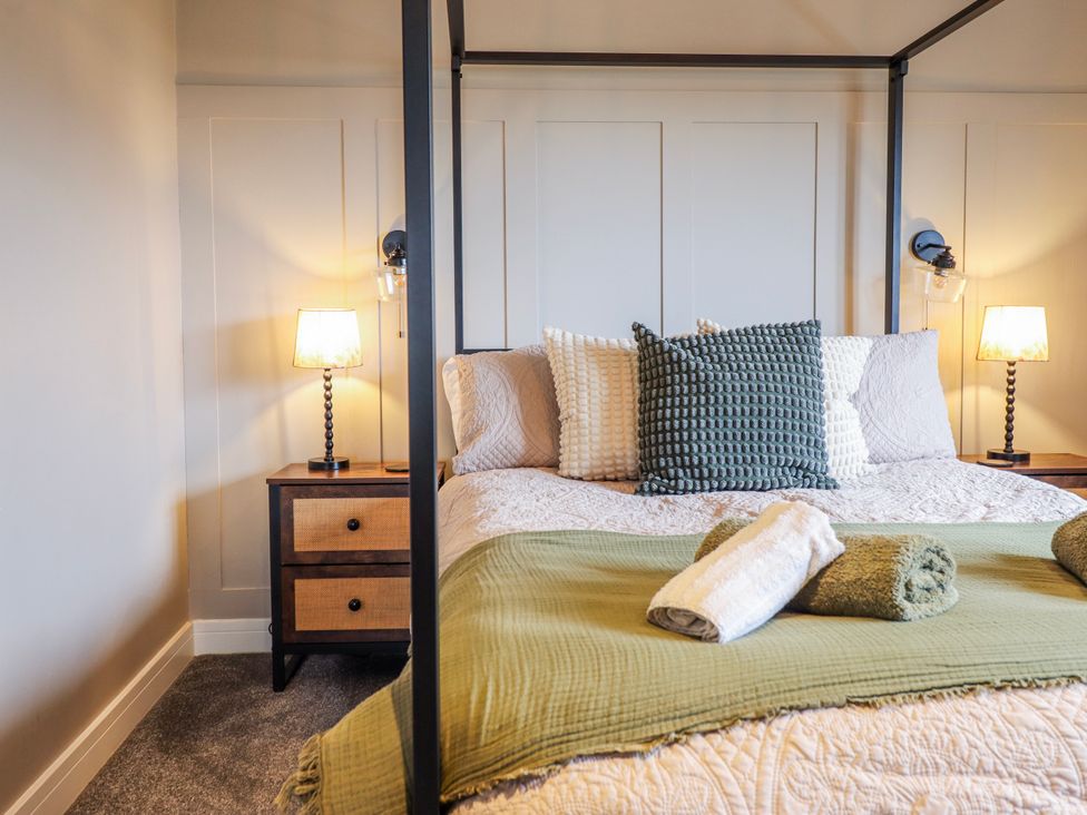 A bedroom with a four-poster bed and nightstands at Hafod Y Bryn Harlech