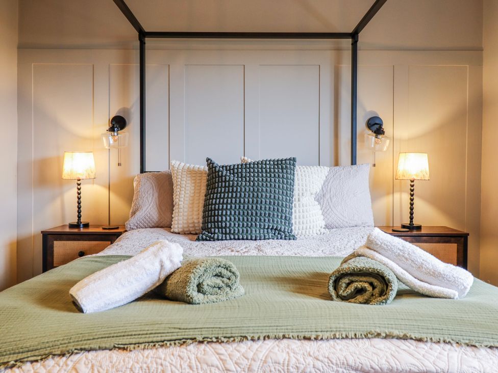 A bedroom with a bed and nightstands at Hafod Y Bryn Harlech